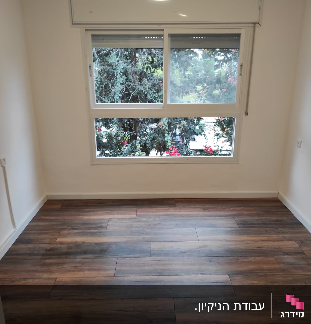 חדר ריק עם רצפת עץ נקייה וחלון גדול